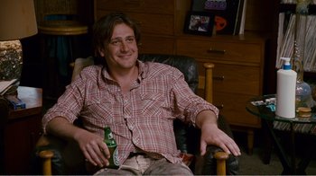 Movie still from “I Love You, Man” (2009), directed by John Hamburg – A man sitting in a chair holding a bottle of beer; Medium shot, Over the shoulder angle