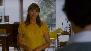Movie still from “I Love You, Man” (2009), directed by John Hamburg – A woman in a yellow shirt standing in front of a table; Medium shot, Over the shoulder angle