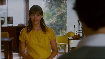 Movie still from “I Love You, Man” (2009), directed by John Hamburg – A woman in a yellow dress in front of a table; Medium shot, Over the shoulder angle