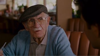 Movie still from “I Love You, Man” (2009), directed by John Hamburg – An old man wearing glasses and a hat; Close Up shot, Over the shoulder angle