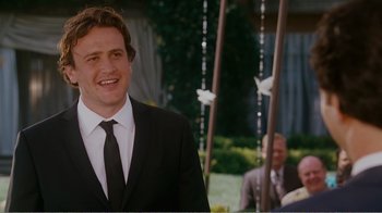 Movie still from “I Love You, Man” (2009), directed by John Hamburg – A man in a suit and tie standing in front of a group of people; Medium shot, Over the shoulder angle