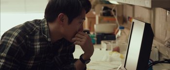 Movie still from “I Origins” (2014), directed by Mike Cahill – A man sitting at a table with his hands under his chin; Close Up shot, Over the shoulder angle