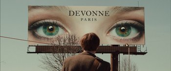 Movie still from “I Origins” (2014), directed by Mike Cahill – A person standing in front of a large billboard; Extreme Close Up shot, Over the shoulder angle