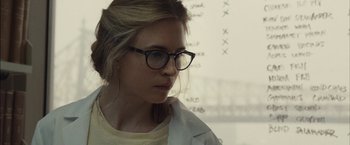 Movie still from “I Origins” (2014), directed by Mike Cahill – A woman wearing glasses and a white shirt looking to her left; Close Up shot, Over the shoulder angle