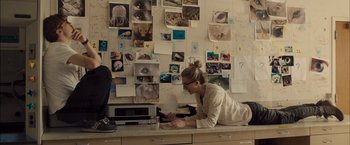 Movie still from “I Origins” (2014), directed by Mike Cahill – A woman sitting on top of a counter next to a microwave oven; Wide shot, High angle