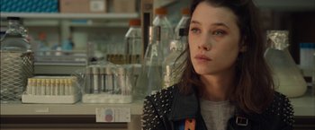 Movie still from “I Origins” (2014), directed by Mike Cahill – A woman in a leather jacket is looking at the camera; Close Up shot, Over the shoulder angle