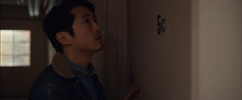 Movie still from “I Origins” (2014), directed by Mike Cahill – A man standing in front of a door looking up; Close Up shot, Over the shoulder angle