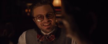 Movie still from “I Origins” (2014), directed by Mike Cahill – A man wearing glasses and a bow tie smiling; Close Up shot, Over the shoulder angle