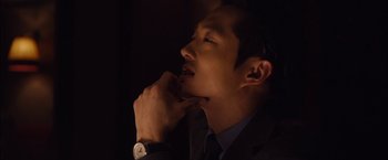 Movie still from “I Origins” (2014), directed by Mike Cahill – A man in a suit and tie with his hand on his chin; Close Up shot, Over the shoulder angle