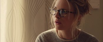 Movie still from “I Origins” (2014), directed by Mike Cahill – A woman wearing glasses and a striped shirt; Close Up shot, Over the shoulder angle