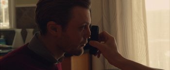 Movie still from “I Origins” (2014), directed by Mike Cahill – A man looking into a person's eyes with a cell phone in front of him; Close Up shot, Over the shoulder angle