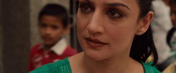 Movie still from “I Origins” (2014), directed by Mike Cahill – A woman's face with a boy in the background; Close Up shot, Over the shoulder angle