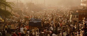Movie still from “I Origins” (2014), directed by Mike Cahill – A large group of people gathered in an open air market; Extreme Wide shot, High angle