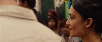 Movie still from “I Origins” (2014), directed by Mike Cahill – A group of people gathered around a woman; Close Up shot, Over the shoulder angle