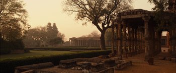 Movie still from “I Origins” (2014), directed by Mike Cahill – An old park with trees and a building in the background; Extreme Wide shot, High angle