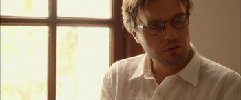 Movie still from “I Origins” (2014), directed by Mike Cahill – A person wearing glasses and a white shirt; Close Up shot, Low angle