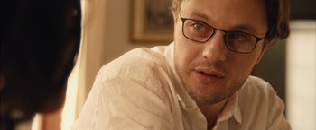 Movie still from “I Origins” (2014), directed by Mike Cahill – A person wearing a white shirt and glasses; Close Up shot, Over the shoulder angle