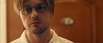 Movie still from “I Origins” (2014), directed by Mike Cahill – A person wearing glasses and a white shirt; Close Up shot, Low angle