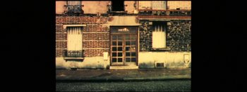 Movie still from “I Stand Alone” (1998), directed by Gaspar Noé – An image of a building that has been boarded up; Extreme Wide shot, High angle