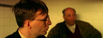 Movie still from “I Stand Alone” (1998), directed by Gaspar Noé – A man and a woman are sitting next to each other; Close Up shot, Over the shoulder angle