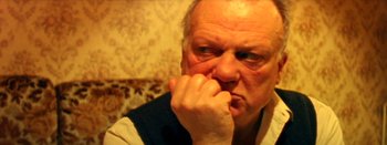 Movie still from “I Stand Alone” (1998), directed by Gaspar Noé – An older man is holding his hands to his face; Close Up shot, High angle