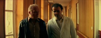 Movie still from “I Stand Alone” (1998), directed by Gaspar Noé – Two men standing next to each other in a room; Medium shot, Low angle