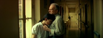 Movie still from “I Stand Alone” (1998), directed by Gaspar Noé – An older man hugging a young girl in a hallway; Medium shot, Low angle