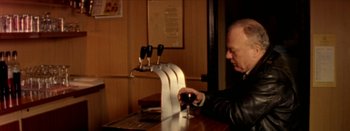 Movie still from “I Stand Alone” (1998), directed by Gaspar Noé – A man sitting at a table with a glass of red wine; Medium shot, High angle