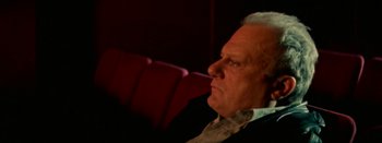Movie still from “I Stand Alone” (1998), directed by Gaspar Noé – An older man sitting in a chair looking off to his right; Close Up shot, Low angle
