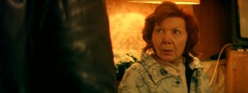 Movie still from “I Stand Alone” (1998), directed by Gaspar Noé – An older woman is looking into the camera; Close Up shot, Over the shoulder angle