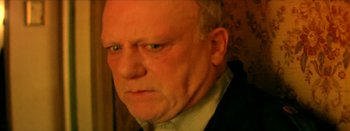 Movie still from “I Stand Alone” (1998), directed by Gaspar Noé – An older man with a goatee looking at the camera; Close Up shot, High angle