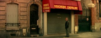 Movie still from “I Stand Alone” (1998), directed by Gaspar Noé – A man standing in front of a closed store; Wide shot, High angle
