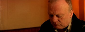 Movie still from “I Stand Alone” (1998), directed by Gaspar Noé – An older man in a black suit looking down; Close Up shot, Low angle