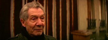 Movie still from “I Stand Alone” (1998), directed by Gaspar Noé – An older man in a black jacket looks at the camera; Close Up shot, High angle
