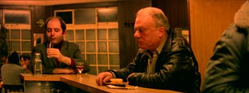 Movie still from “I Stand Alone” (1998), directed by Gaspar Noé – An older man sitting at a bar with a glass of red wine; Medium shot, Over the shoulder angle