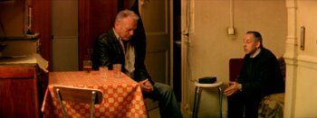 Movie still from “I Stand Alone” (1998), directed by Gaspar Noé – An older man sitting at a table with a glass of wine; Medium shot, High angle