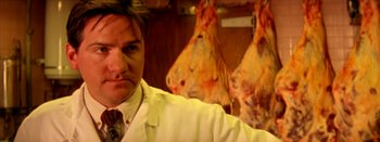 Movie still from “I Stand Alone” (1998), directed by Gaspar Noé – A man standing in front of a bunch of meat; Close Up shot, Low angle