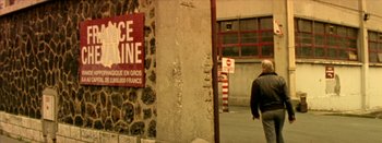 Movie still from “I Stand Alone” (1998), directed by Gaspar Noé – A man walking down a street next to a building; Wide shot, High angle
