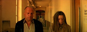 Movie still from “I Stand Alone” (1998), directed by Gaspar Noé – A man and a woman walking down a hall way; Medium shot, Low angle