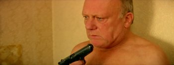 Movie still from “I Stand Alone” (1998), directed by Gaspar Noé – A bald man holding a gun in his hand; Close Up shot, High angle