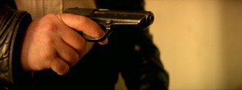 Movie still from “I Stand Alone” (1998), directed by Gaspar Noé – A person holding a gun in their hand; Extreme Close Up shot, High angle