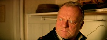 Movie still from “I Stand Alone” (1998), directed by Gaspar Noé – An older man in a military uniform stares at the camera; Close Up shot, Low angle