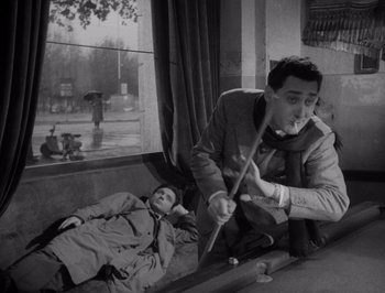 Movie still from “I Vitelloni” (1953), directed by Federico Fellini – A man and a woman laying on the ground; Medium shot, High angle