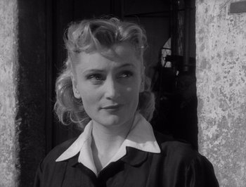 Movie still from “I Vitelloni” (1953), directed by Federico Fellini – A black and white photo of a woman in a dress; Close Up shot, Low angle