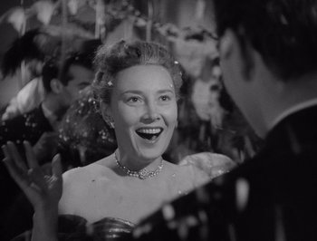 Movie still from “I Vitelloni” (1953), directed by Federico Fellini – An old photo of a woman smiling at a party; Close Up shot, Over the shoulder angle
