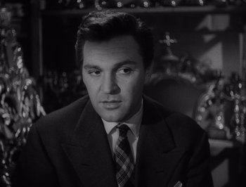 Movie still from “I Vitelloni” (1953), directed by Federico Fellini – Black and white photograph of a man wearing a suit and tie; Close Up shot, Low angle