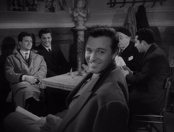 Movie still from “I Vitelloni” (1953), directed by Federico Fellini – Black and white photograph of men sitting at a table; Medium shot, Over the shoulder angle
