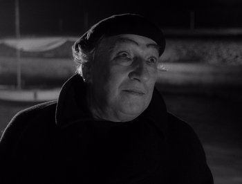 Movie still from “I Vitelloni” (1953), directed by Federico Fellini – An older woman wearing a hat and a black coat; Close Up shot, Low angle