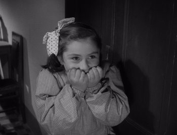 Movie still from “I Vitelloni” (1953), directed by Federico Fellini – A little girl with her hands covering her mouth; Close Up shot, High angle