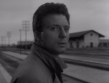 Movie still from “I Vitelloni” (1953), directed by Federico Fellini – Black and white photograph of a man on a train platform; Close Up shot, Low angle